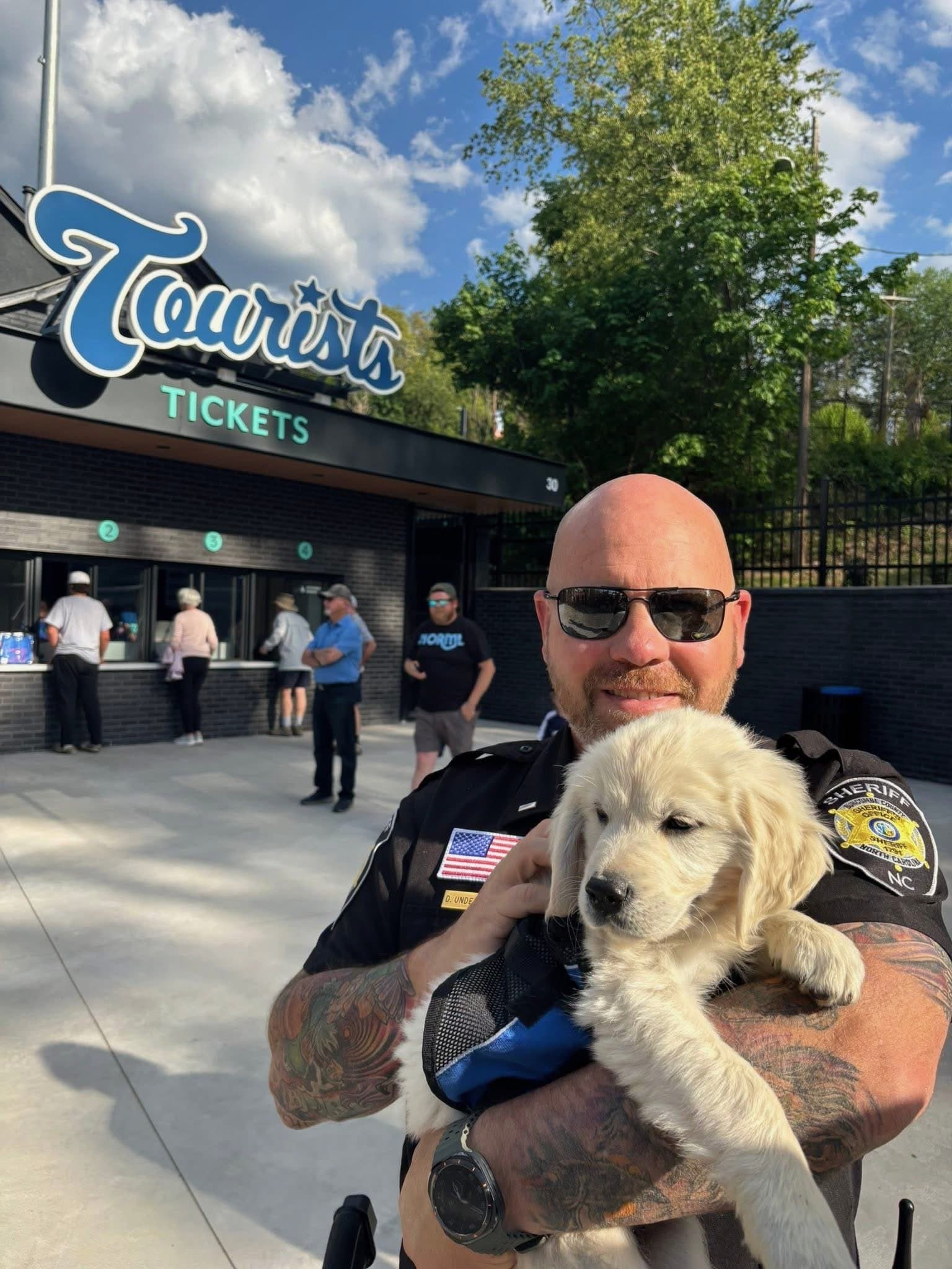 A service dog handler with a Silver Charm puppy